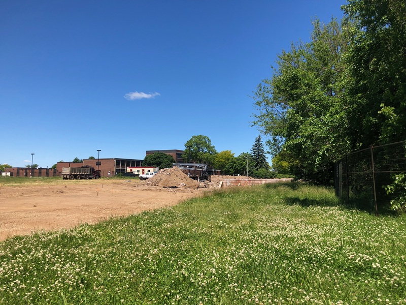 Cleared construction site with earthmoving equipment and material stockpiles